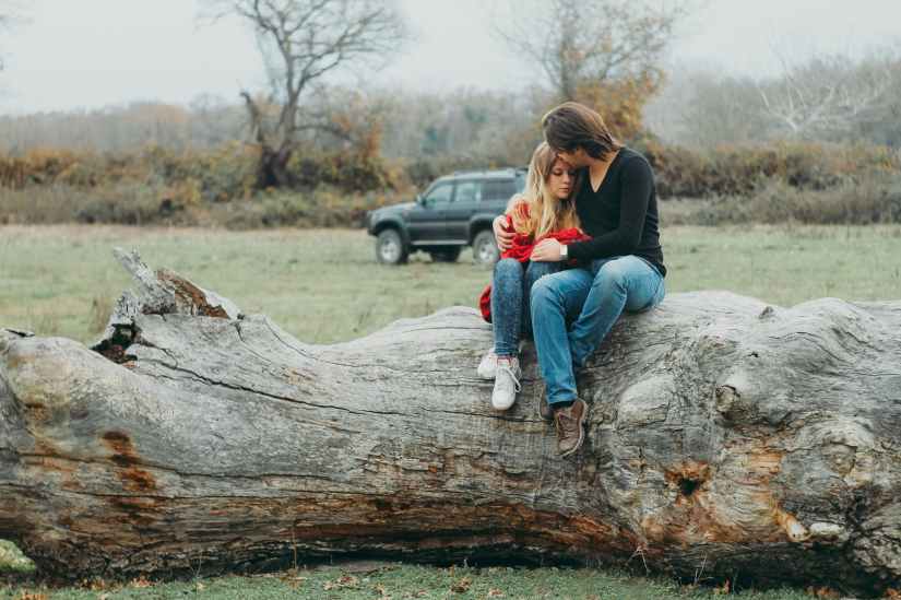 mother and daughter sitting on tree log